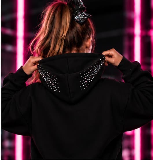 Athlete wearing The Cheer Rhinestone Hoodie, back view showing rhinestone hood trim